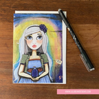 Illustrated card with a character on a wooden surface with a pen next to it.