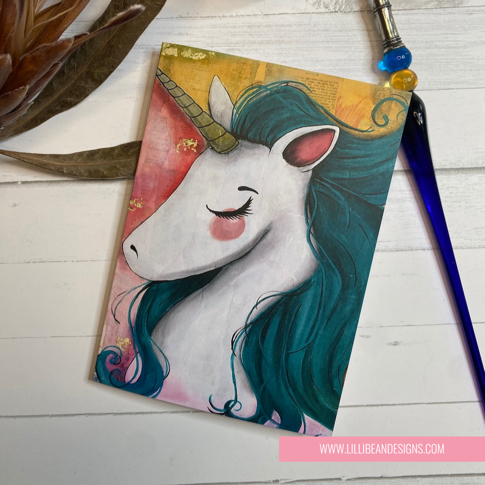 GREETING CARD with a unicorn design on a wooden surface