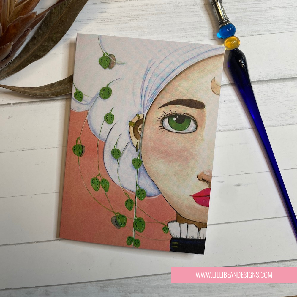 Artistic depiction of a face with green eyes and a CHAIN OF HEARTS PLANT  on a wooden surface with a pen. GREETING CARD