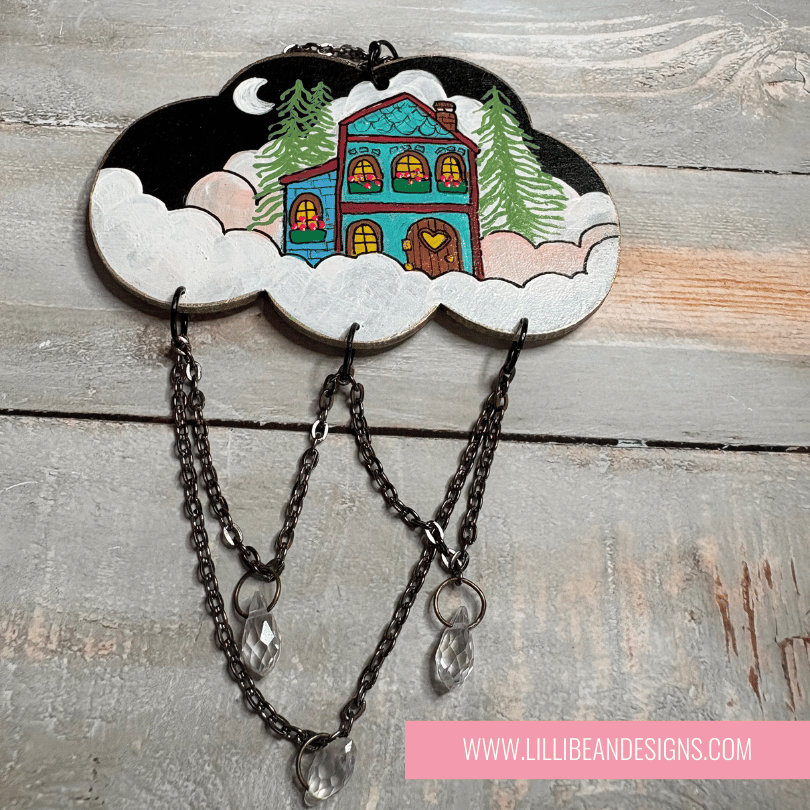 Decorative wall hook with cloud design and house illustration on a wooden surface, featuring LilliBean Designs branding.