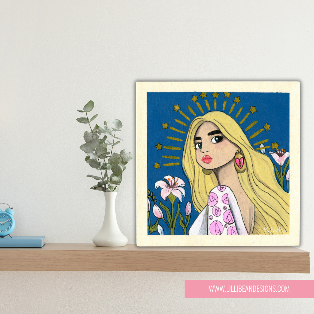 Framed artwork of a stylized portrait with a blue background and floral elements on a shelf.