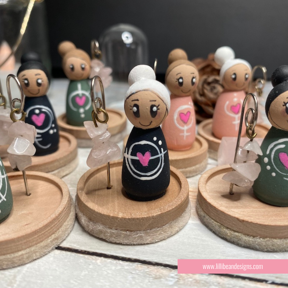 Collection of small figurines with wooden bases on a table.