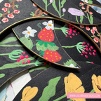Decorative wooden leaves with floral and strawberry designs on a black background. LilliBean Designs