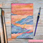 Abstract painting with pink, orange, and blue colors on a wooden surface with art tools.