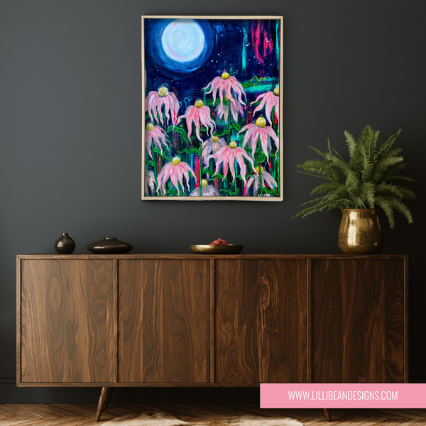 Framed artwork of pink echinacea flowers with a moonlit sky above a wooden cabinet.