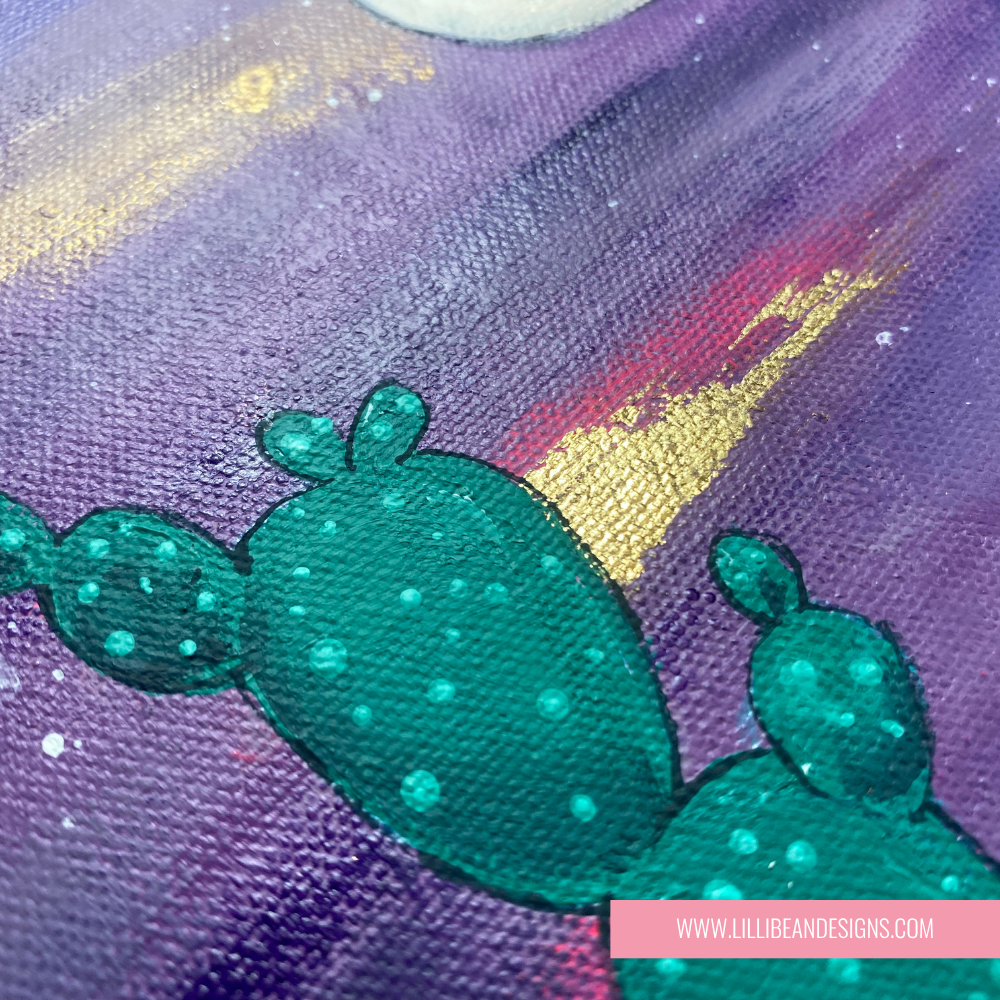 Close-up of a green cactus design on a fabric with purple and gold background
