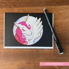 GREETING CARD with unicorn illustration on a wooden surface