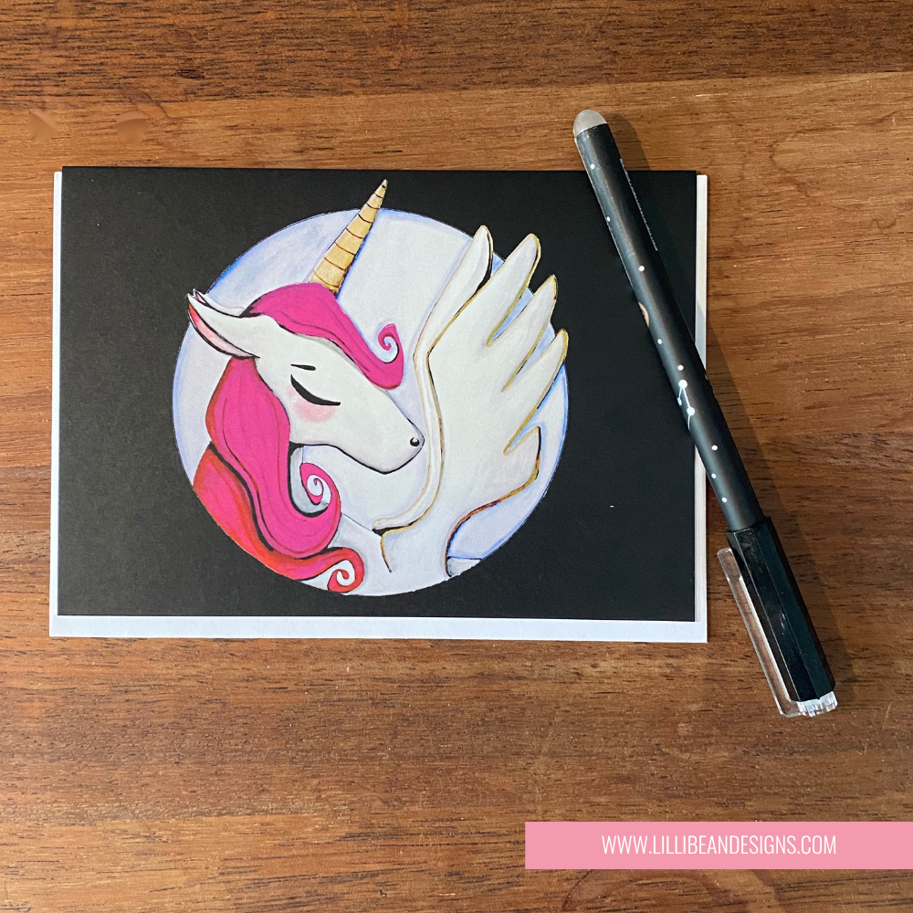 GREETING CARD with unicorn illustration on a wooden surface