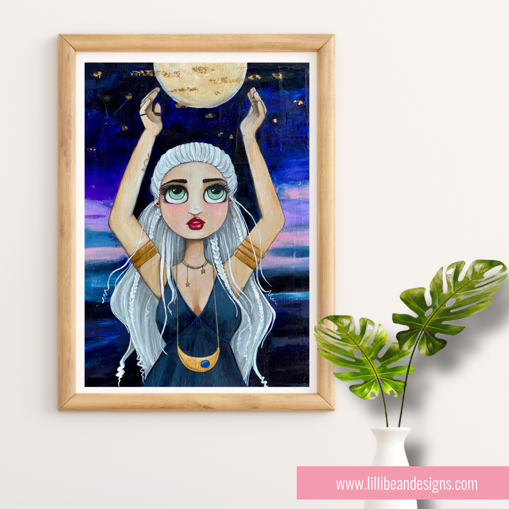 Framed artwork of a woman holding the moon against a starry night sky, with a plant to the right on a white wall.