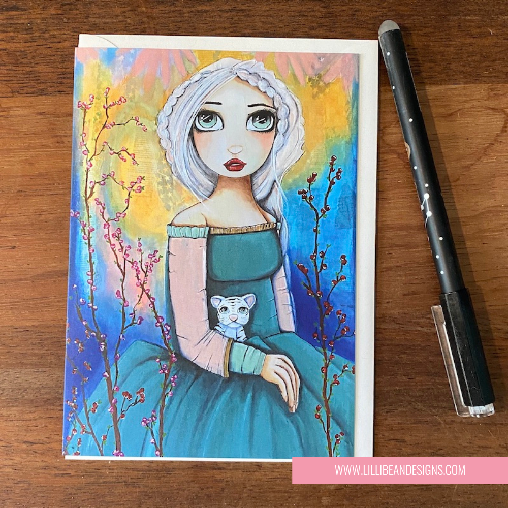 Illustration of a woman in a blue dress with a white cat, on a colorful background with branches, on a wooden surface.  GREETING CARD