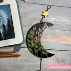 Decorative moon-shaped ornament with floral design on a wooden surface, featuring LillieBean Designs branding.