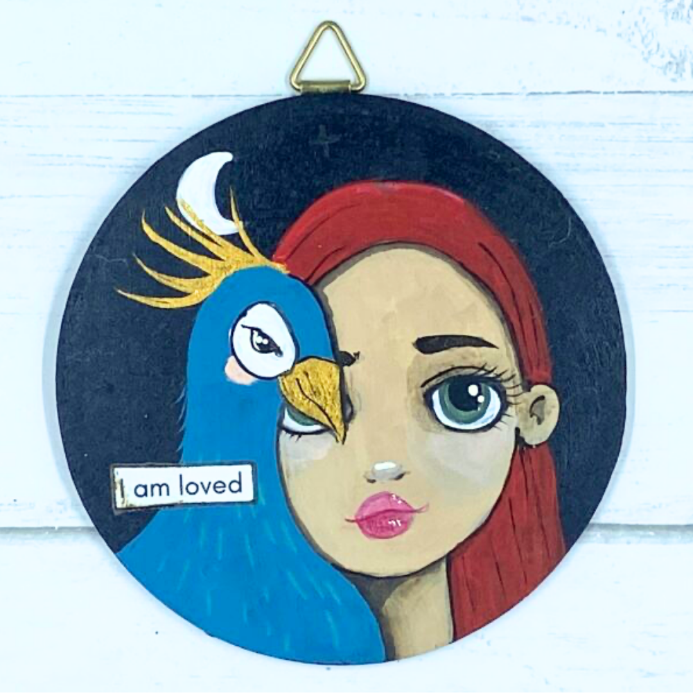 Artistic depiction of a woman's face with a motivational quote on a wooden background, featuring the artist's website.