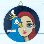 Artistic depiction of a woman's face with a motivational quote on a wooden background, featuring the artist's website.