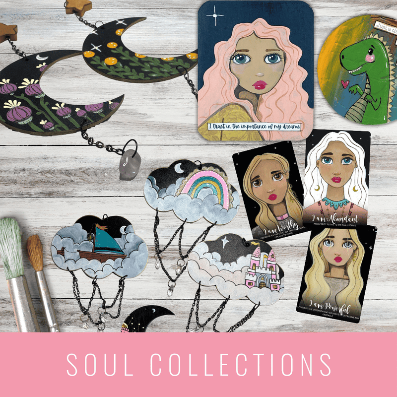 Collection of art cards and jewelry on a wooden surface with 'Soul Collections' branding. LilliBean Designs