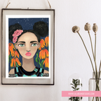 Framed artwork of a woman with flowers in her hair on a white wall.