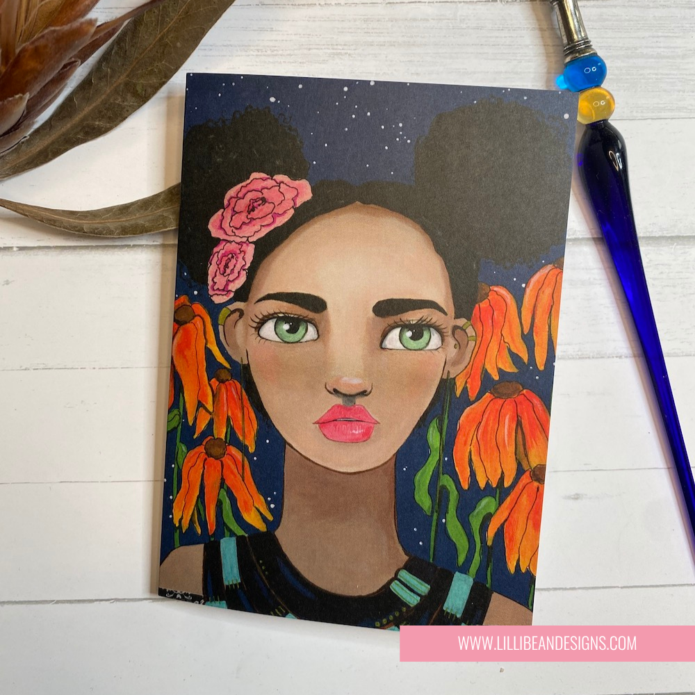 Artistic depiction of a woman with flowers in her hair on a wooden surface with a pen and plant. GREETING CARD