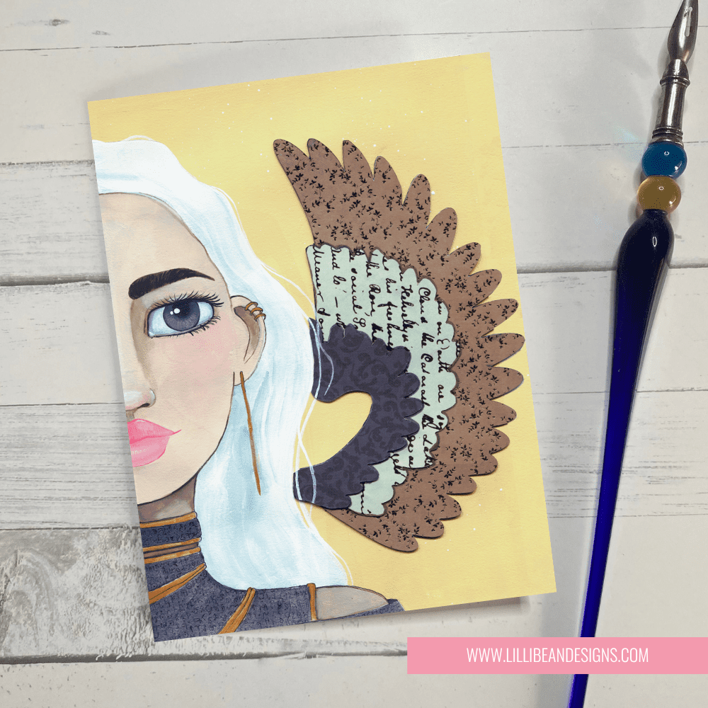 Card with artistic illustration of a ANGEL and decorative elements on a wooden surface.