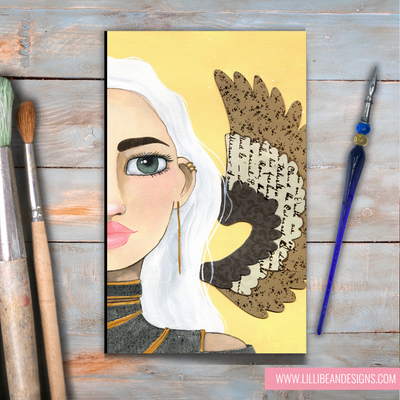 Artistic depiction of a woman with a large feathered headdress on a wooden surface with art supplies.
