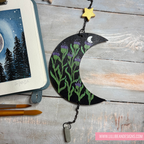 Decorative wall hanging with moon and plant design on a wooden surface, featuring LilliBean Designs branding.