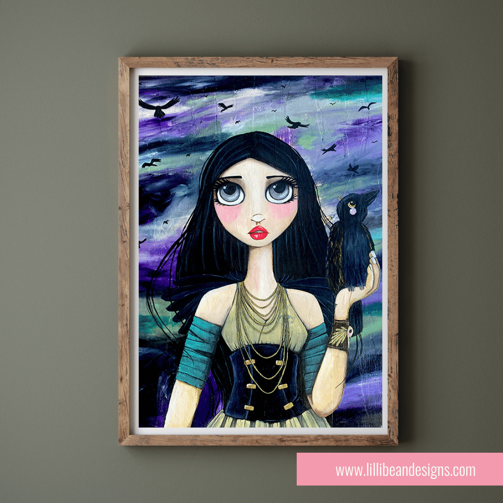 Framed artwork of a woman with a raven on a gray wall, featuring the website www.lillibean designs.com.