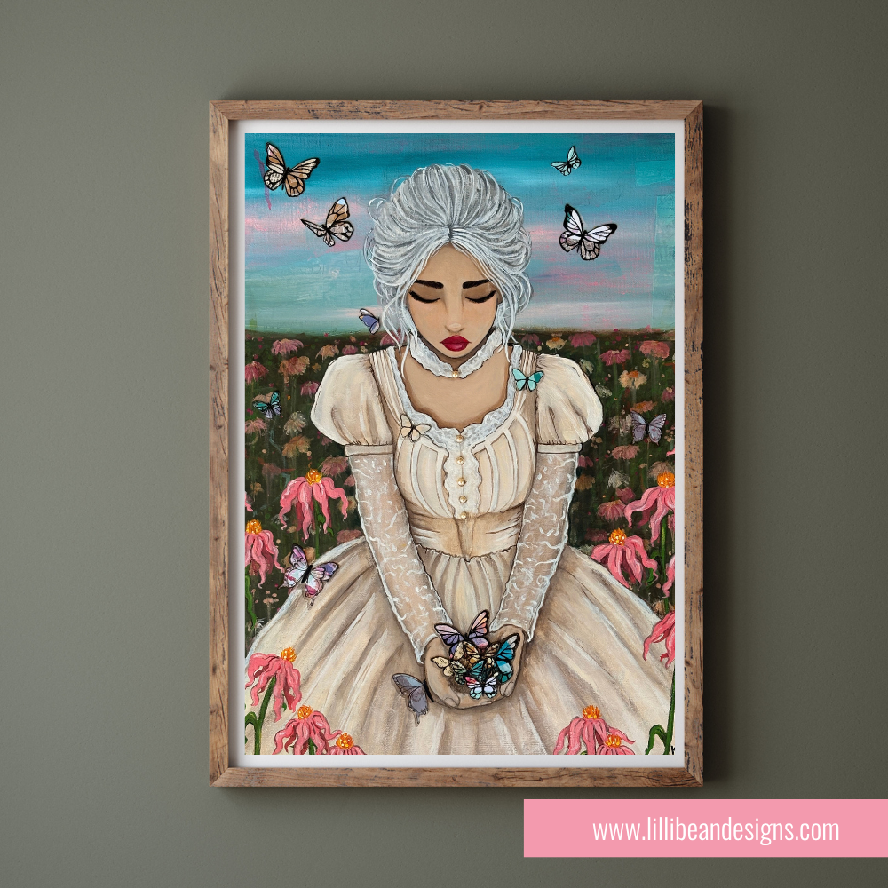 A framed art print featuring a stylized portrait of a woman with white hair, a cream dress, and butterflies in a field, displayed on a dark gray wall. A pink banner at the bottom reads 'www.