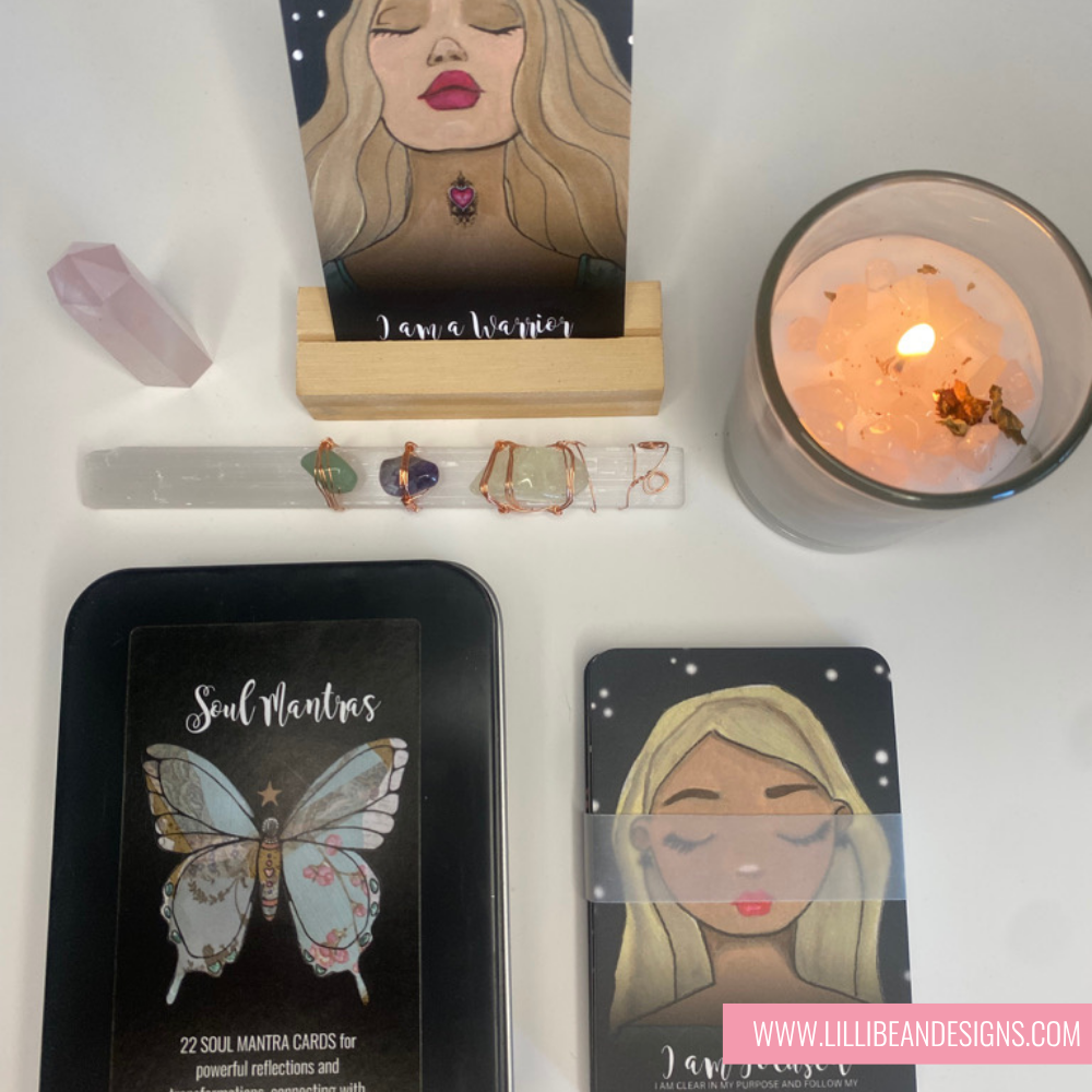 Collection of tarot cards, crystals, and a candle on a white surface with 'LilliIBean Designs' branding.