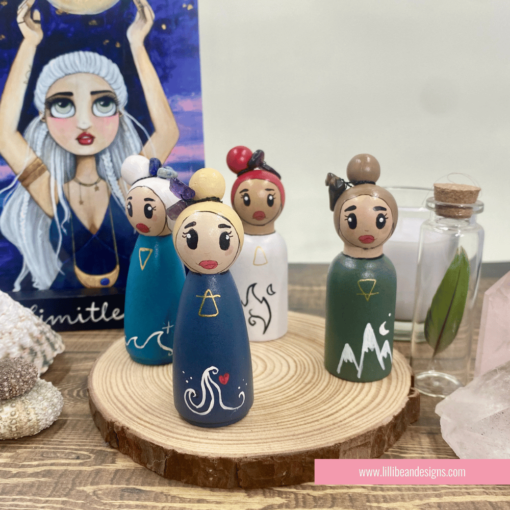 Set of wooden peg dolls with unique designs on a wooden stand, with a blurred background.