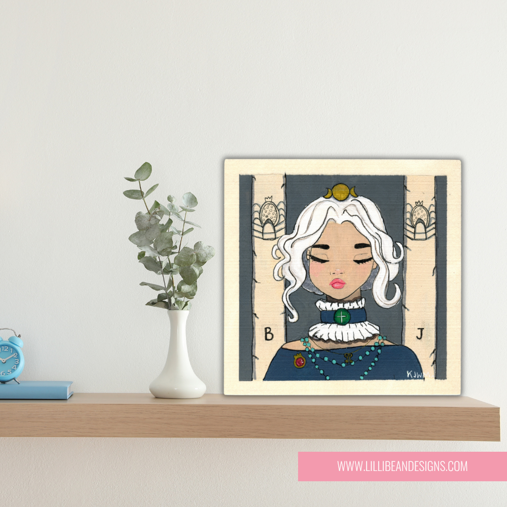 Framed illustration of a woman with white hair on a shelf with decor items.