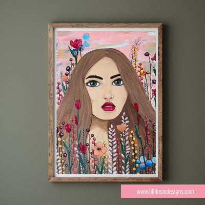 Framed artwork of a woman's face surrounded by flowers on a gray wall.