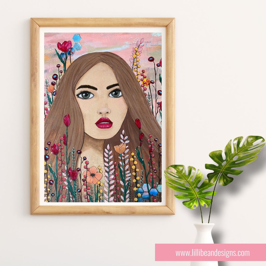 Framed artwork of a woman's face surrounded by flowers on a white wall.