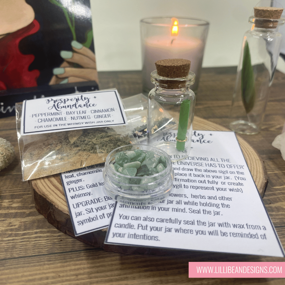 Herbal mixture in a small glass jar with instructions on a wooden surface, surrounded by candles and packaging.