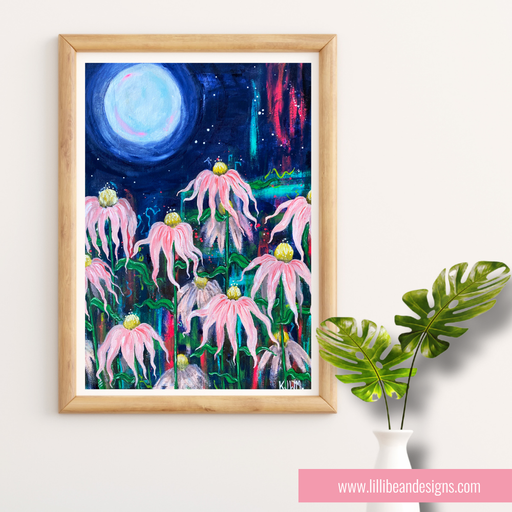 Framed artwork of pink flowers under a moonlit sky, displayed on a white wall with a plant.