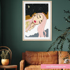 Framed artwork of a woman with pink hair on a green wall above a brown sofa.