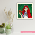Framed artwork of a red-haired woman with a crown holding a fruit, placed on a surface with decorative plants.