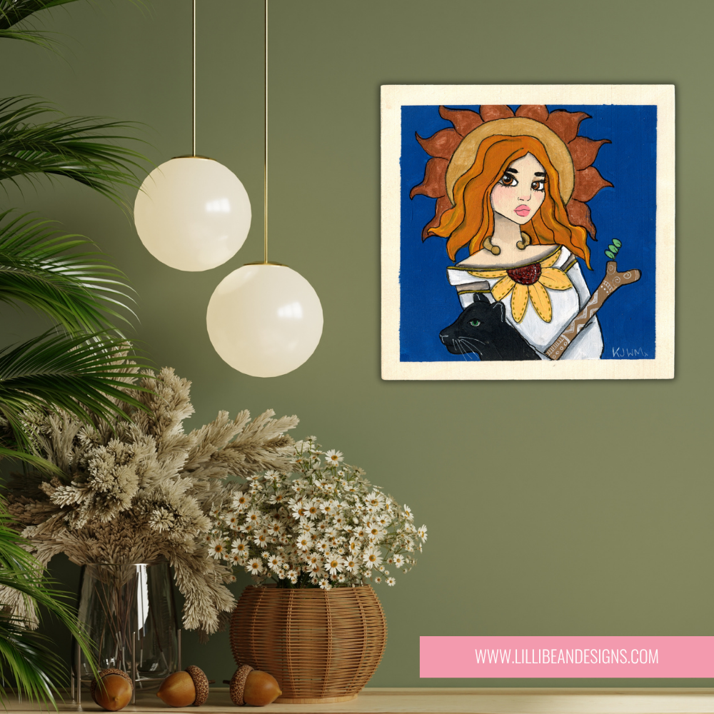 Framed artwork of a woman with sunflower hair on a green wall above a decorative plant and vase.