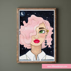 Framed artwork of a person with pink hair and green eyes on a dark background, displayed on a wall.