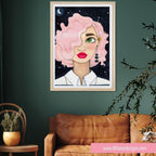 Framed artwork of a woman with pink hair on a green wall above a brown sofa.