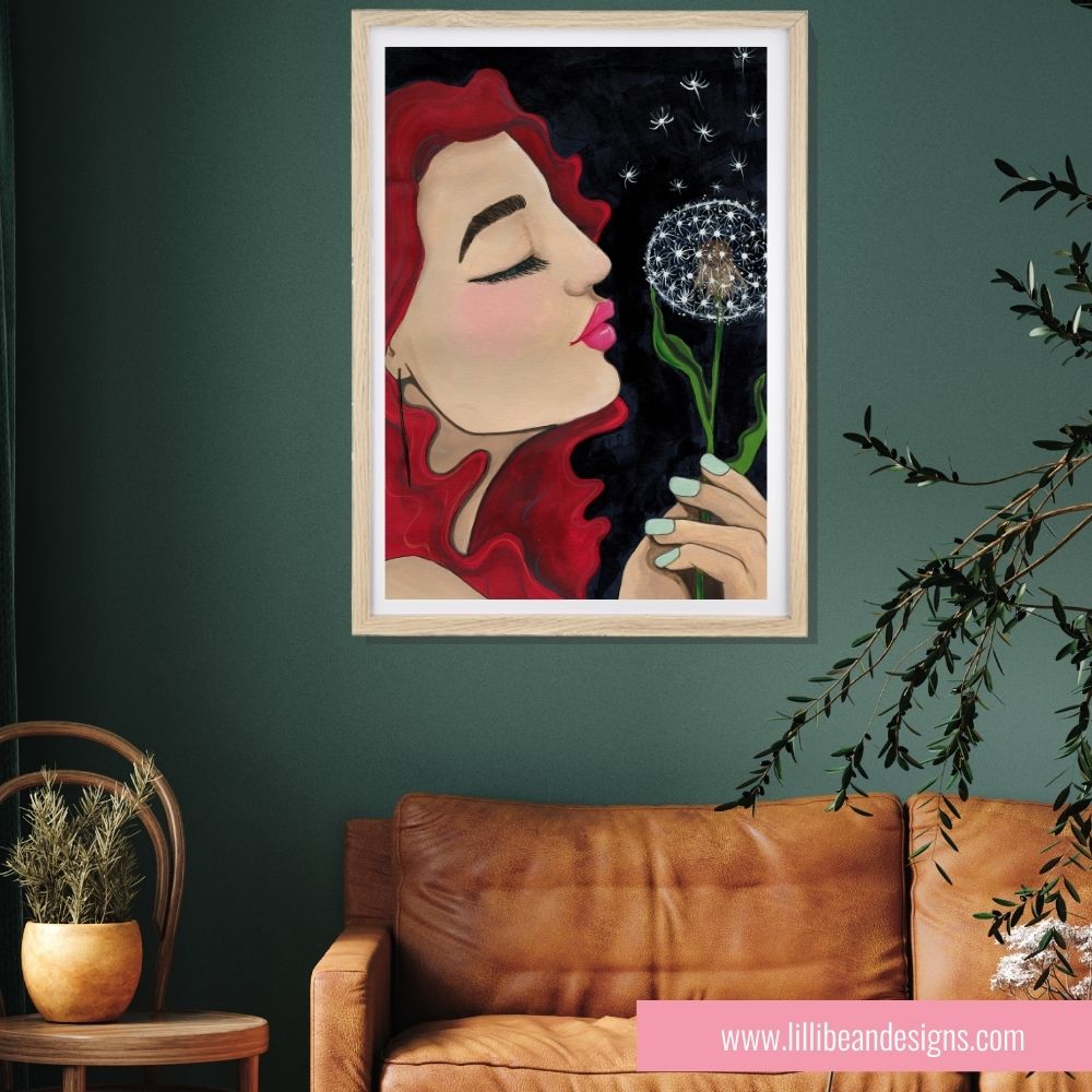 Framed artwork of a woman blowing on a dandelion against a dark background, displayed in a living room.