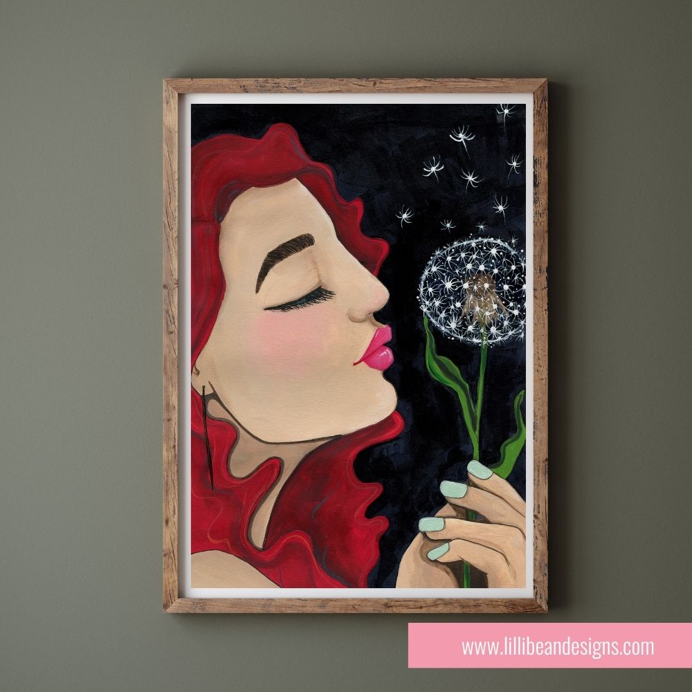 Framed artwork of a woman blowing a dandelion against a dark background, with 'Lillie Bean Designs' branding.